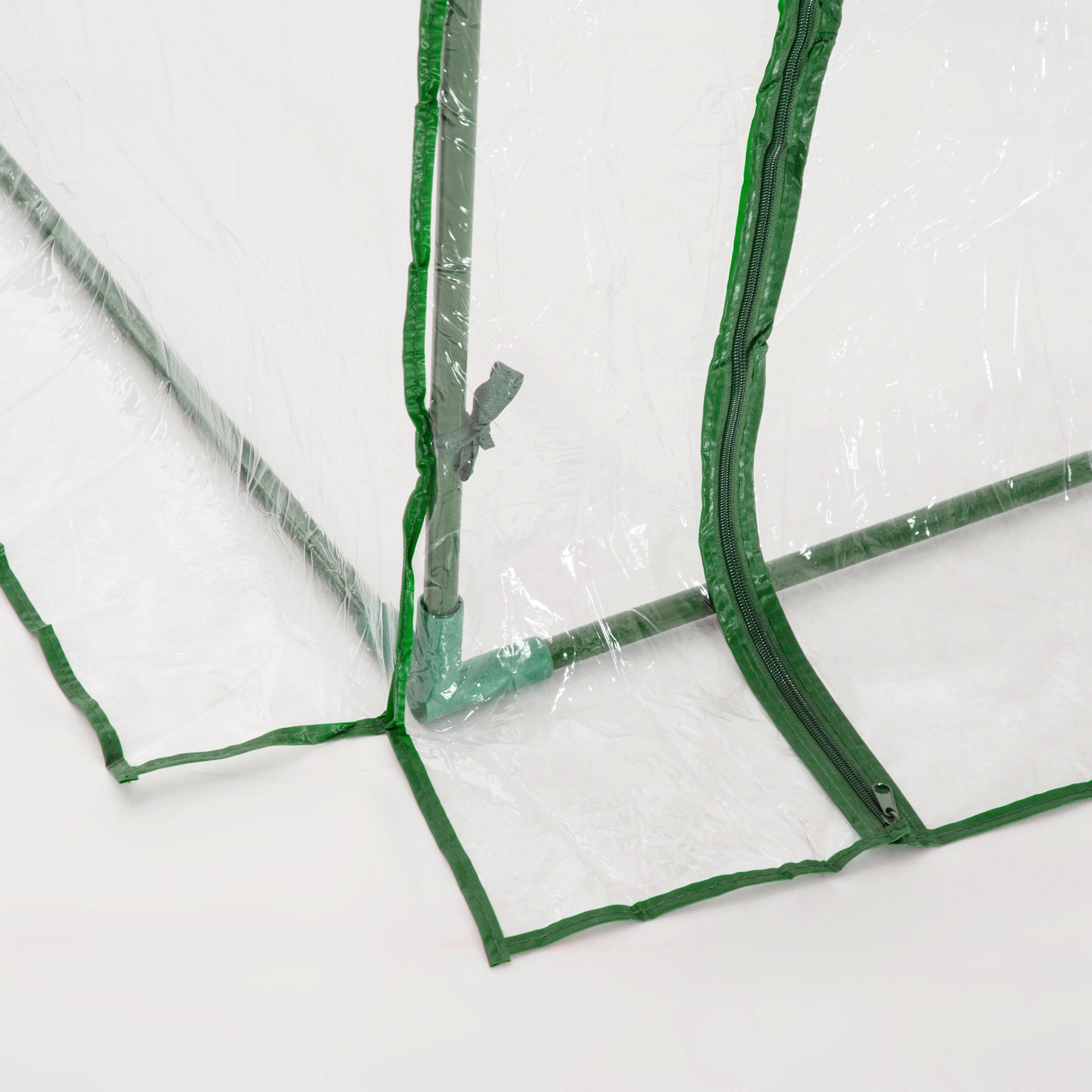 Estructura metálica verde con cubierta de plástico transparente y cremallera.