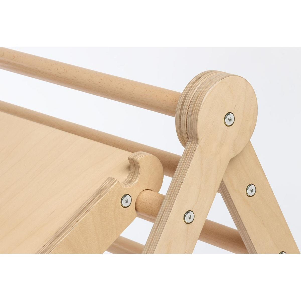 Nahaufnahme von hellen Holzteilen mit sichtbaren Schrauben eines Kinderspielgeräts.