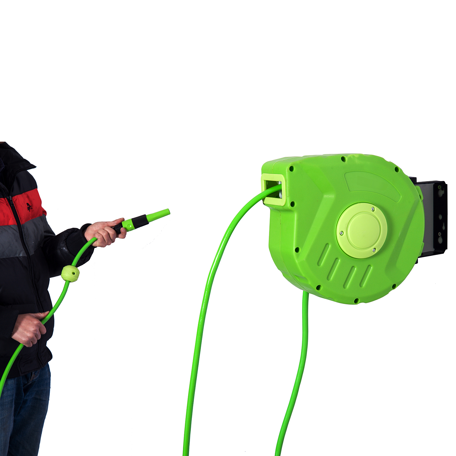 Una persona con chaqueta tira de una manguera verde que sale de un carrete de pared verde.
