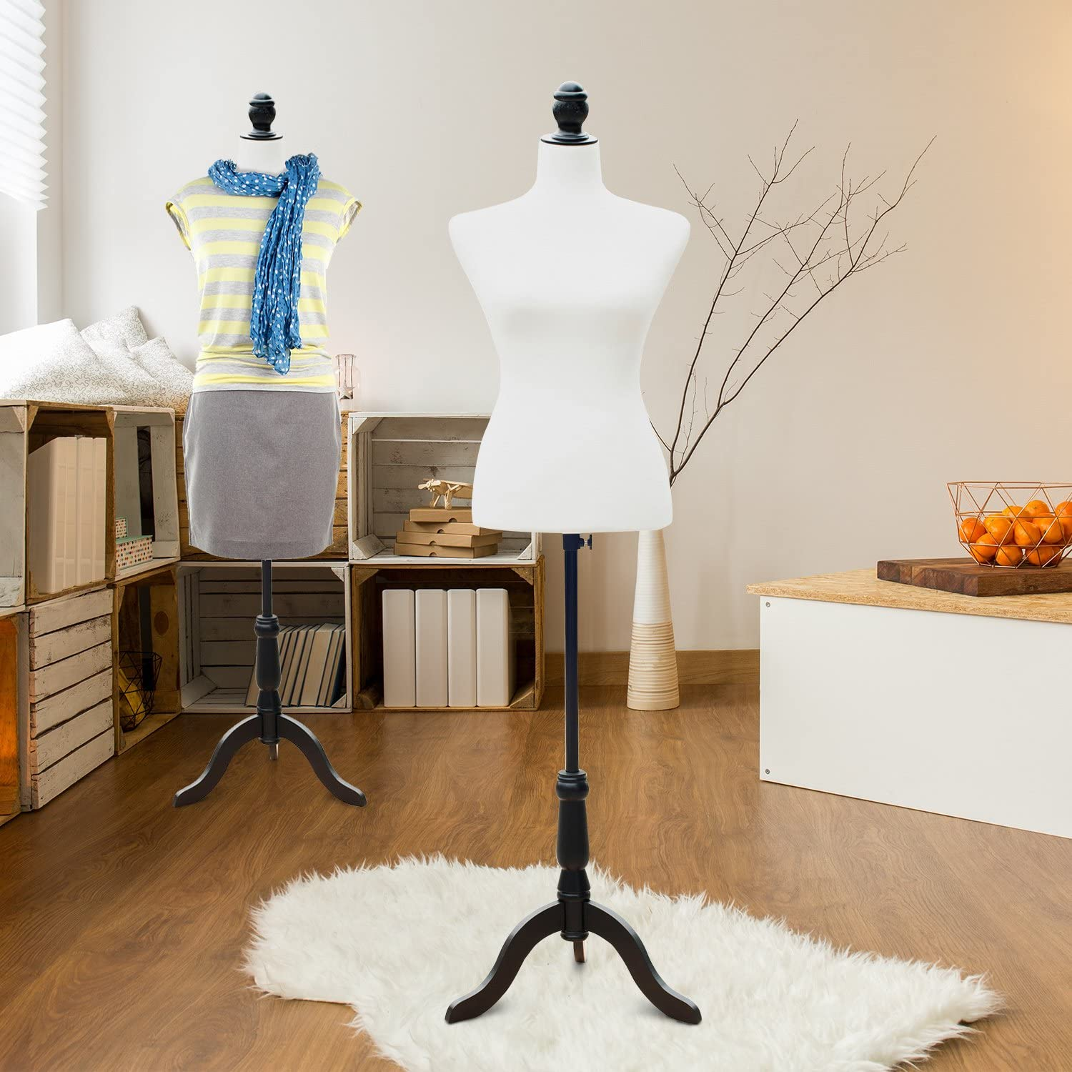 Dos maniquíes blancos se encuentran en una habitación luminosa con pisos de madera y una alfombra blanca.