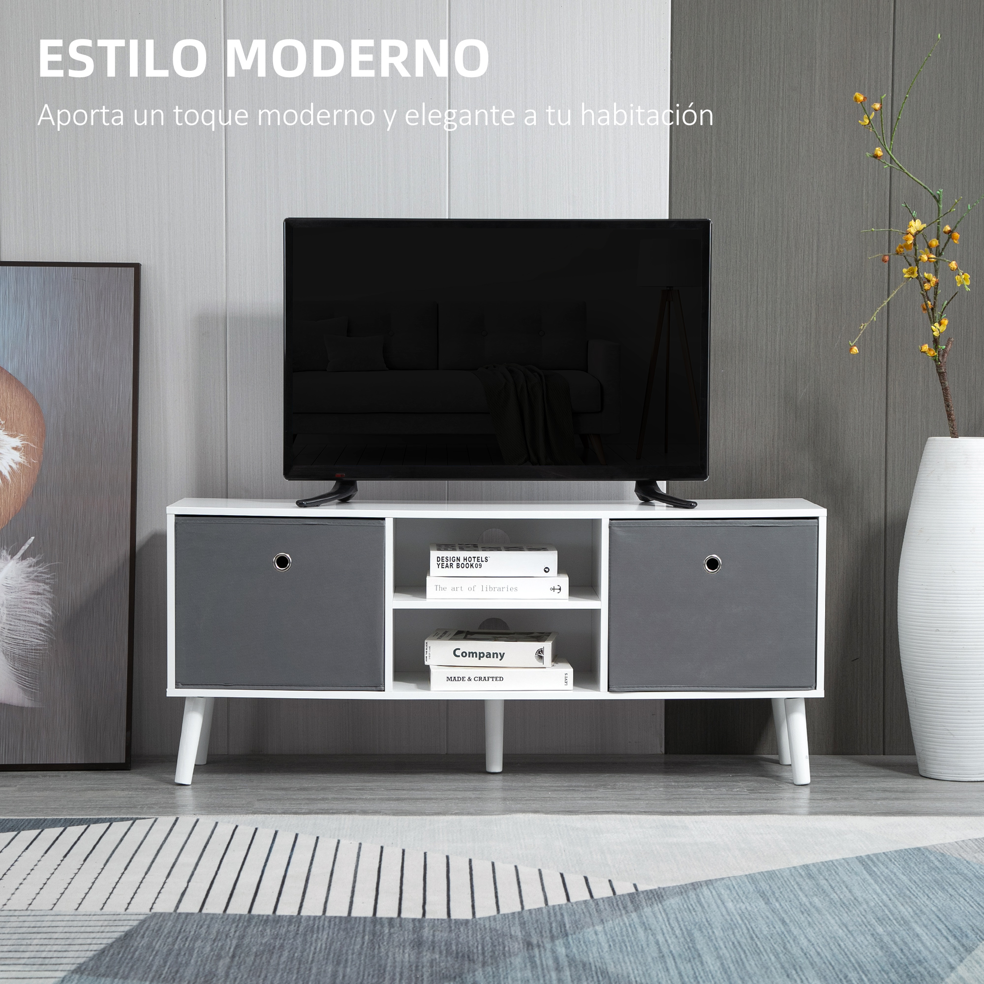 Mueble de TV moderno blanco con cajones grises, libros y un televisor encima, frente a una pared gris.