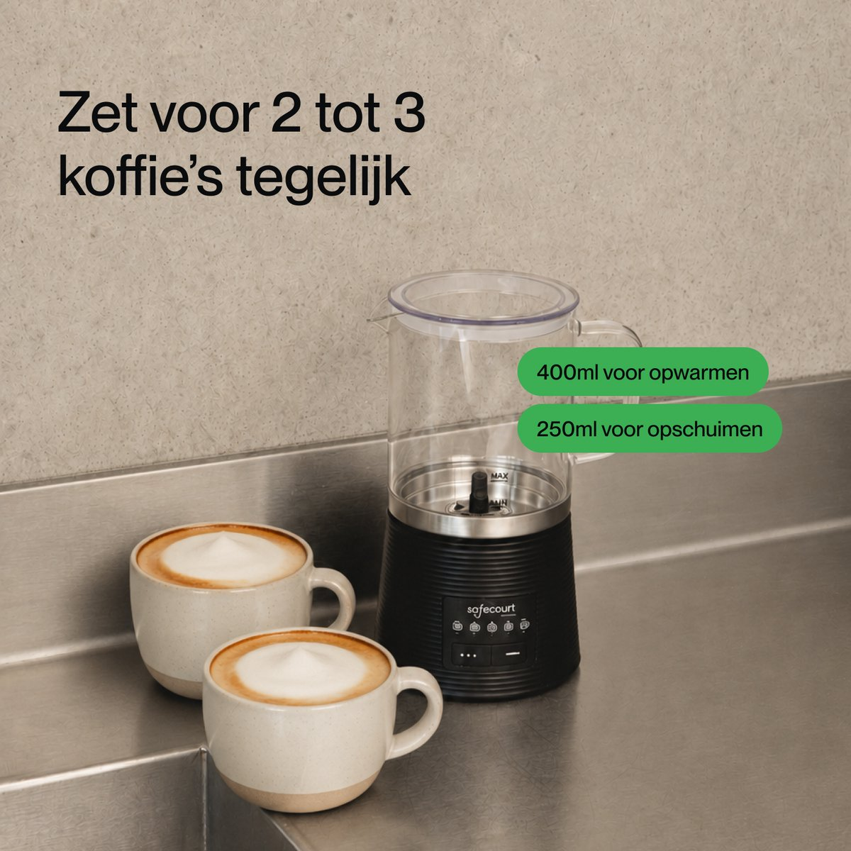 Een zwarte melkopschuimer en twee kopjes cappuccino staan op een aanrecht met tekst.