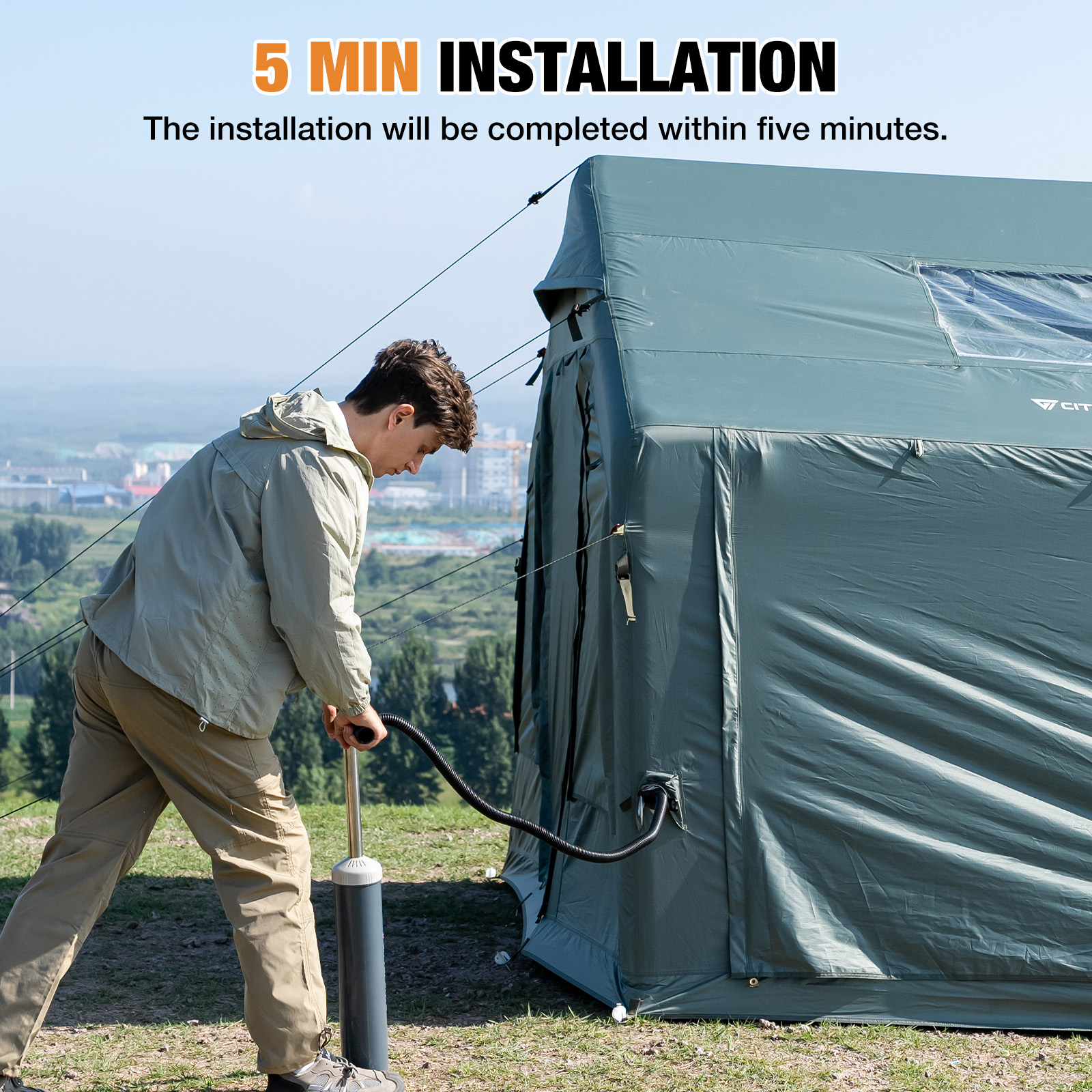 A man is inflating a large green tent outdoors.
