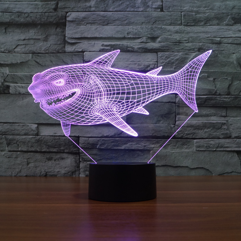 Eine violette 3D-Haifisch-Drahtmodell-Lampe steht auf einem schwarzen Sockel vor einer grauen Steinwand.
