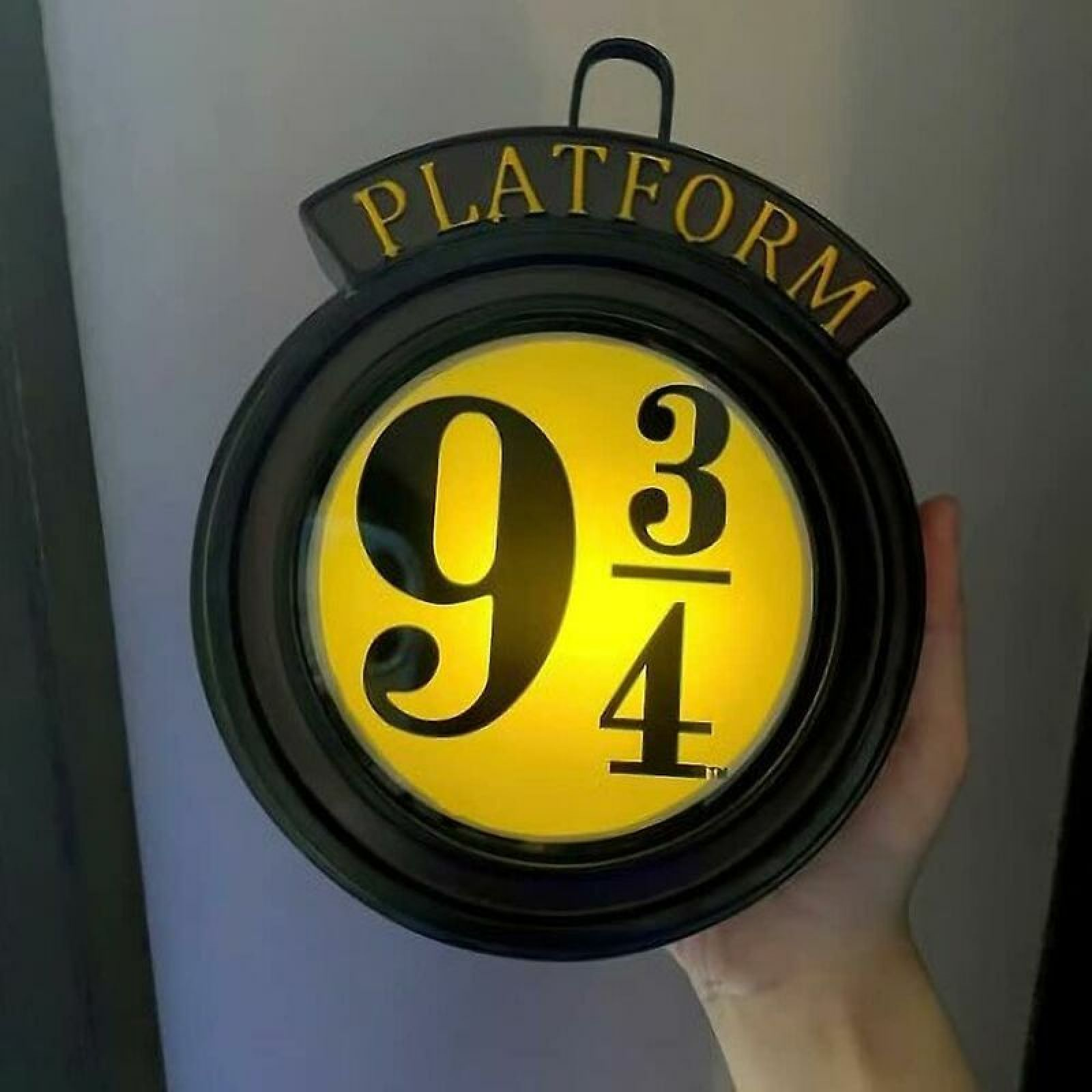 Runde gelbe Leuchte mit schwarzem Rand und der Aufschrift Plattform 9 3/4.