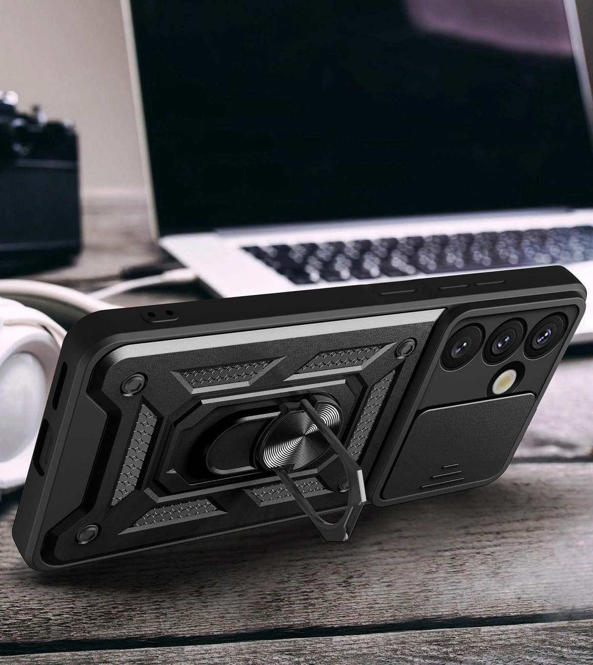 Custodia per smartphone nera con supporto integrato e copri-fotocamera su un tavolo di legno.