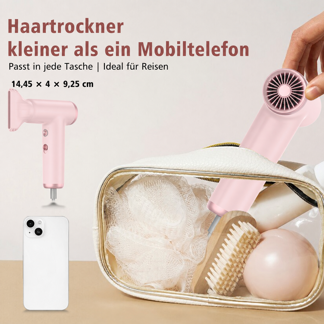 Ein kompakter, rosa Haartrockner wird neben einer Kulturtasche und einem Smartphone gezeigt.