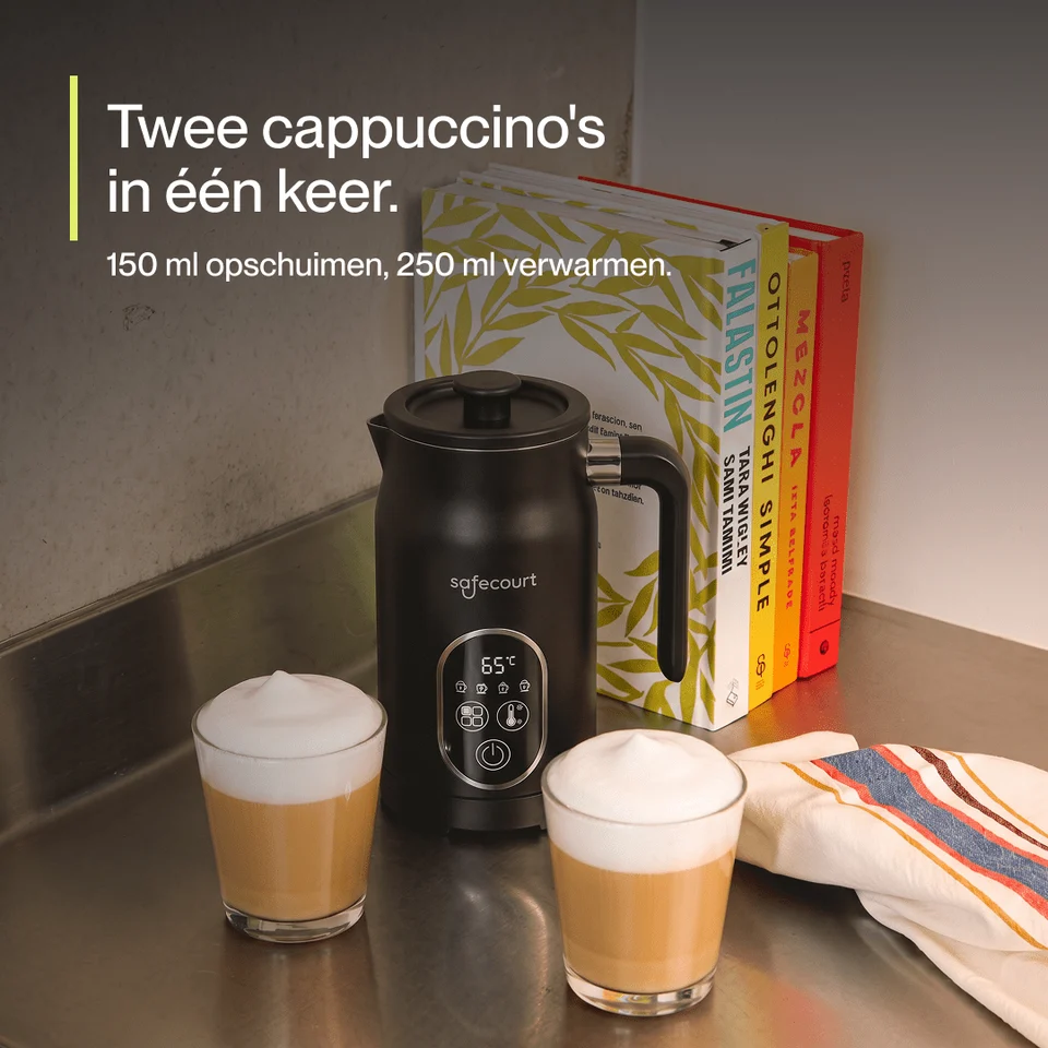 Un mousseur à lait noir est posé à côté de deux cappuccinos et de livres.