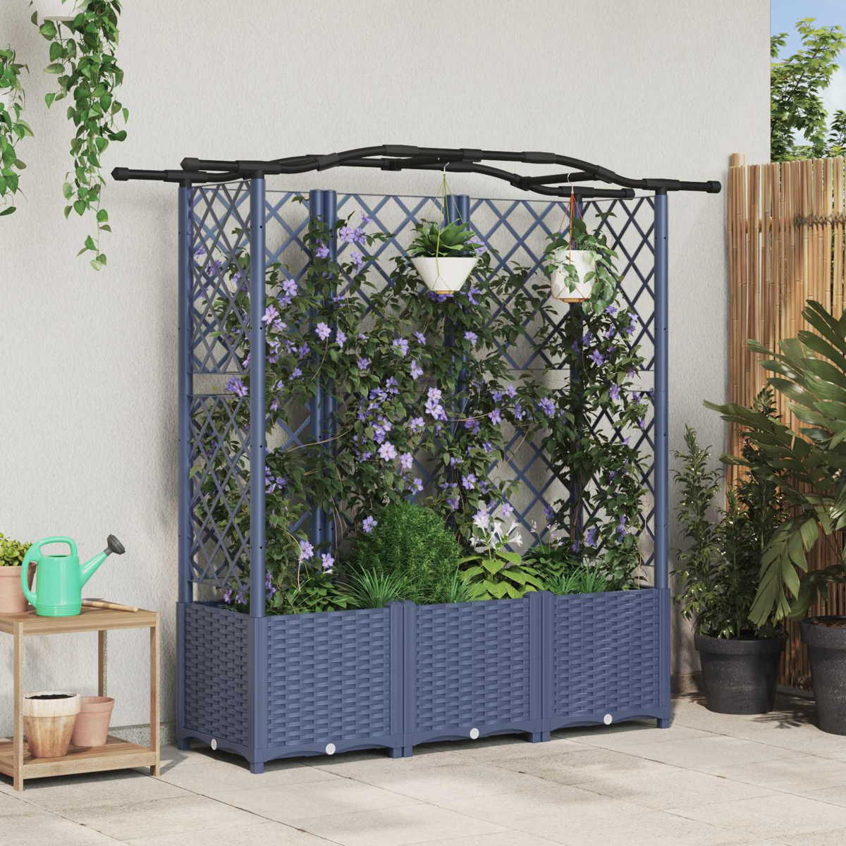 Dunkelblauer Rankkasten mit kletternden lila Blumen, Hängetöpfen und schwarzem Bogenrahmen auf einer Terrasse.