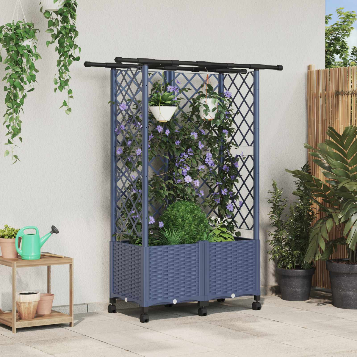 Ein blaues Pflanzengitter mit Rollen, lila Blütenranken und Töpfen auf einer Terrasse mit weiteren Pflanzen.