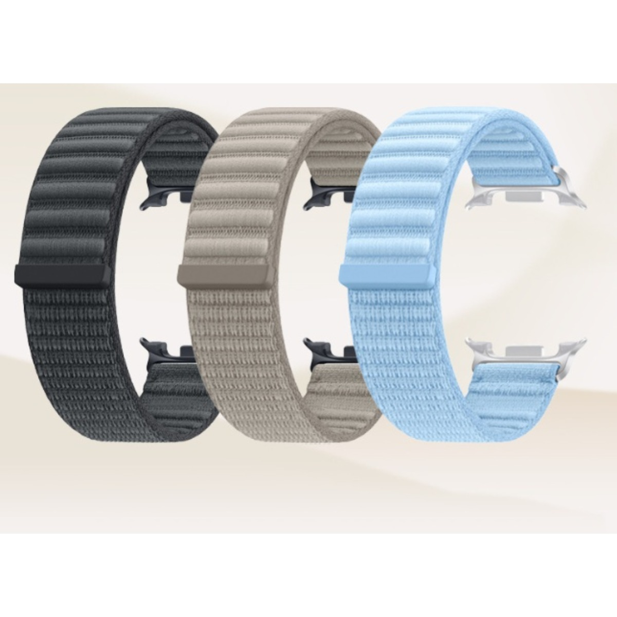 Drei gerippte Smartwatch-Armbänder in Schwarz, Beige und Hellblau stehen nebeneinander auf hellem Hintergrund.