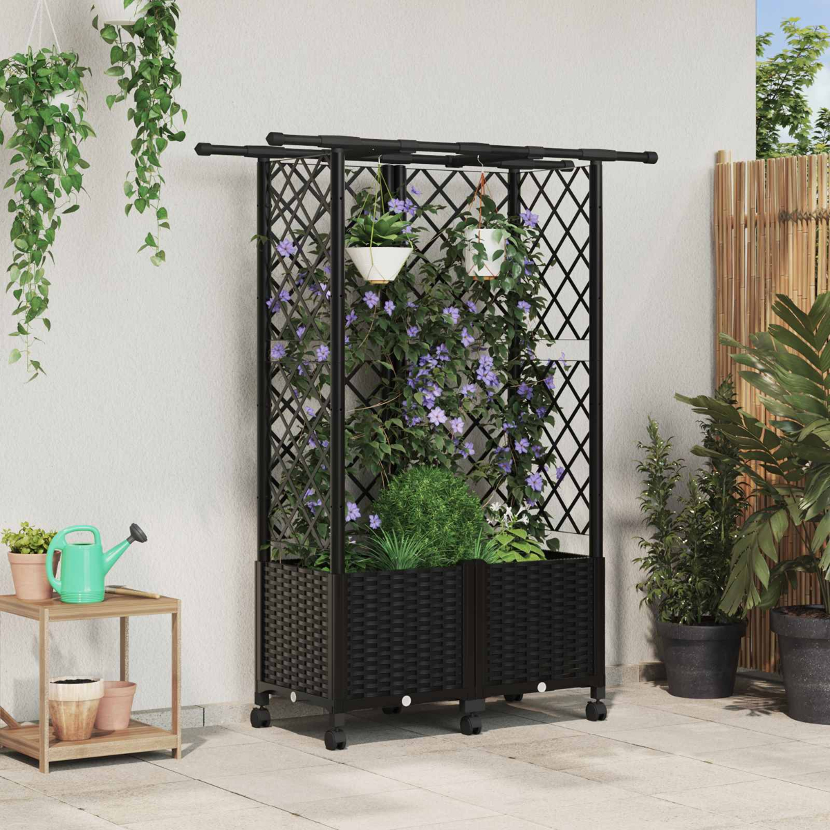 Ein schwarzes Metallgitter mit Pflanzkasten auf Rollen steht auf einer Terrasse, bewachsen mit violetten Blumen.