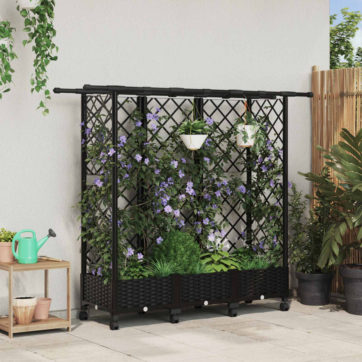 Schwarzes Spalier mit Rollen, bewachsen mit violetten Blumen und hängenden Töpfen auf einer Terrasse.