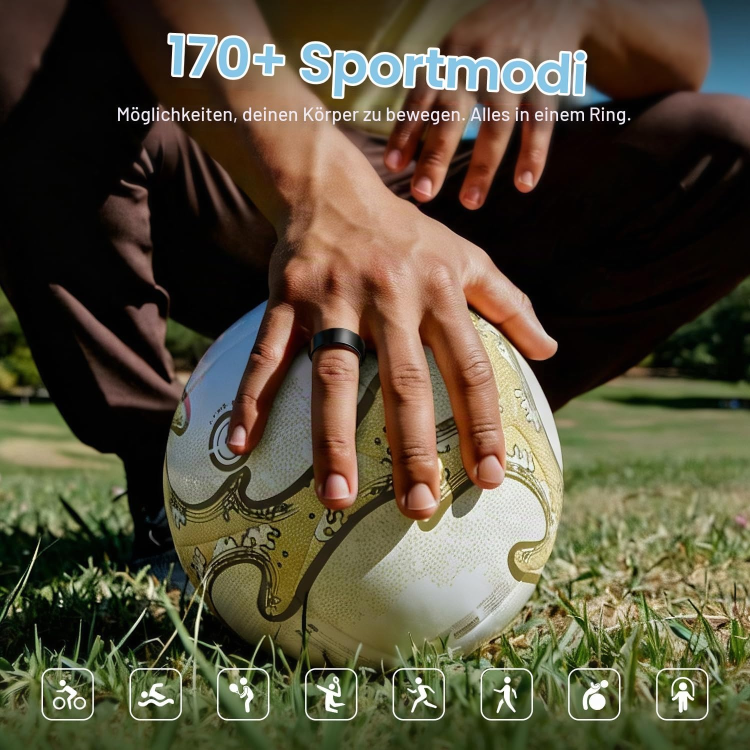 Eine Person sitzt draußen und hält eine Hand mit einem schwarzen Ring auf einen Fussball im Gras.