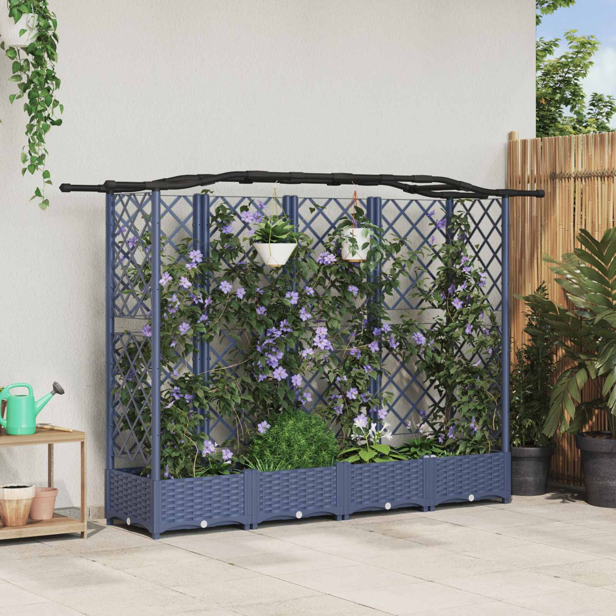 Ein blauer Rankkasten mit Kletterpflanzen und violetten Blüten steht auf einer Terrasse.