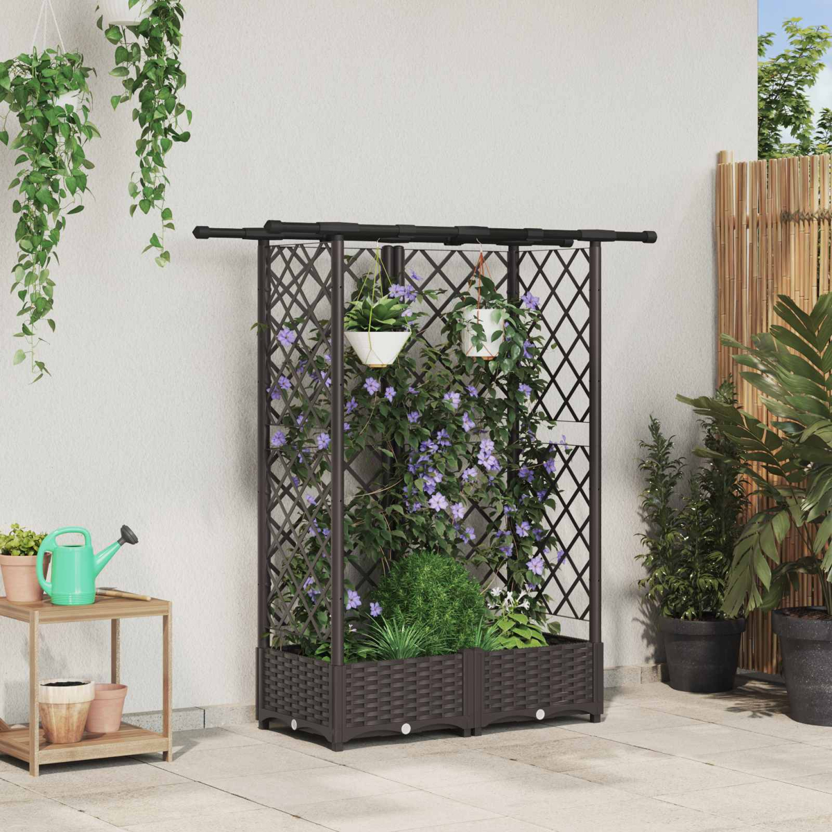 Ein brauner Gartenspalier-Pflanzkasten mit violetten Kletterblumen, Hängetöpfen und einer Gießkanne.