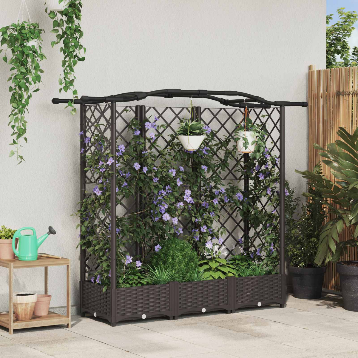 Ein braunes Rankgitter mit Pflanzkästen, bewachsen mit grünen Pflanzen und violetten Blüten, auf einer Terrasse.