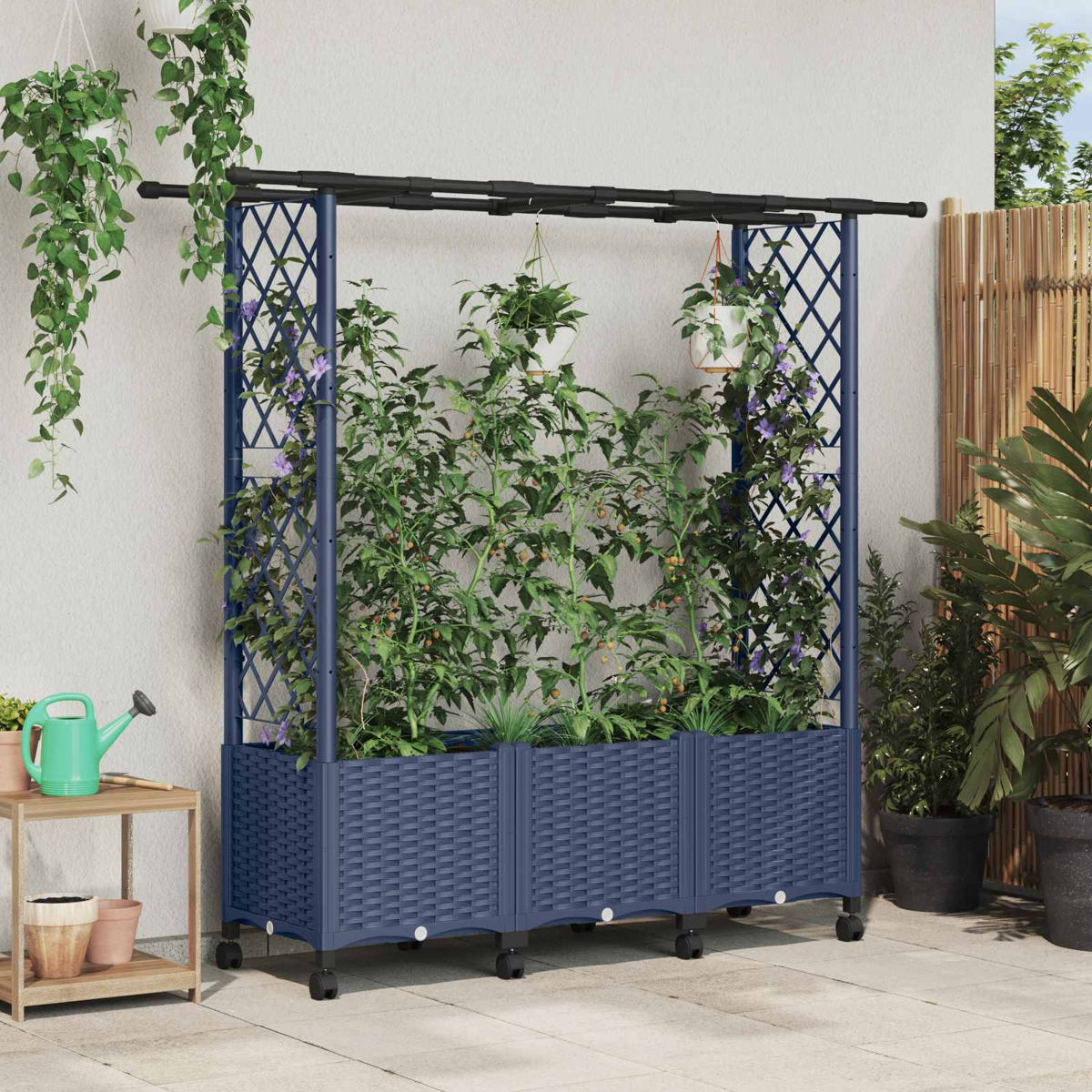 Ein blauer Garten-Pflanzkübel mit Spalier auf Rädern zeigt grüne Pflanzen und hängende Töpfe.