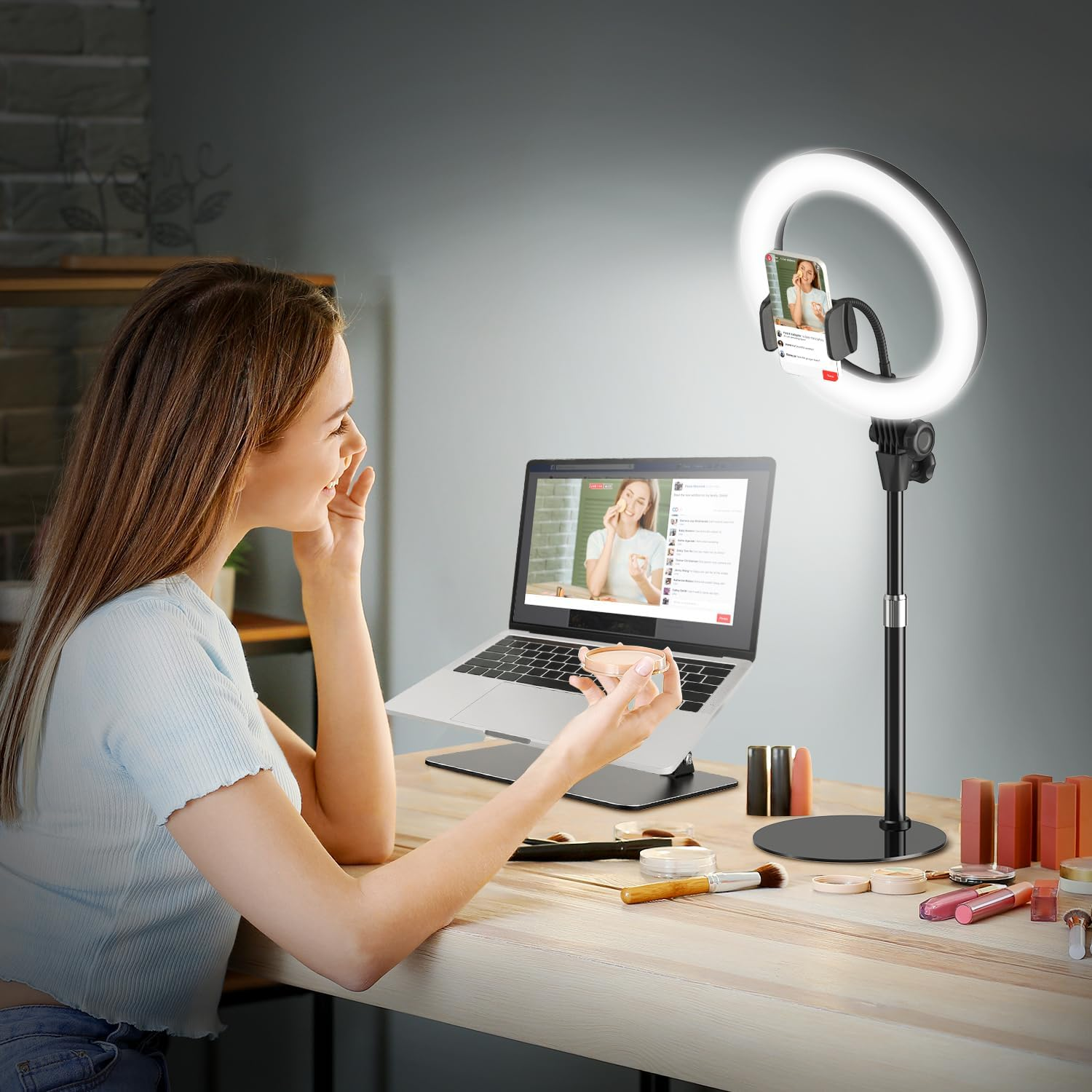 Eine Frau sitzt am Schreibtisch mit Laptop und Ringlicht, um Make-up-Tutorials zu streamen.
