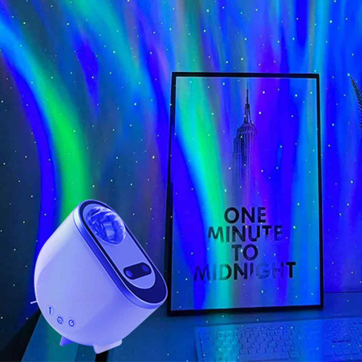 Ein Lichtprojektor wirft einen blauen und grünen Aurora-Effekt an eine Wand, neben einem gerahmten Poster.