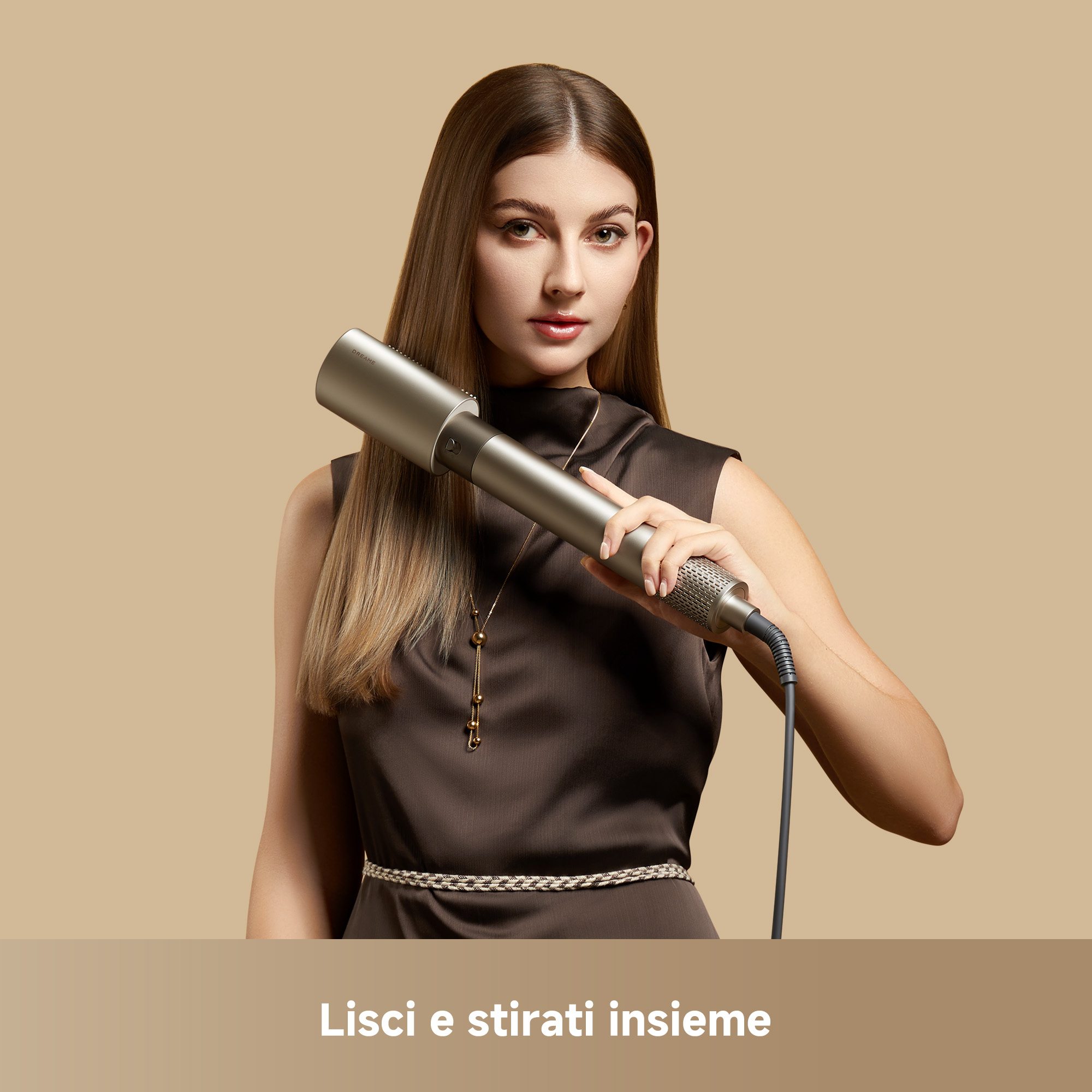 Una donna in abito marrone tiene un styler per capelli argentato su sfondo beige.