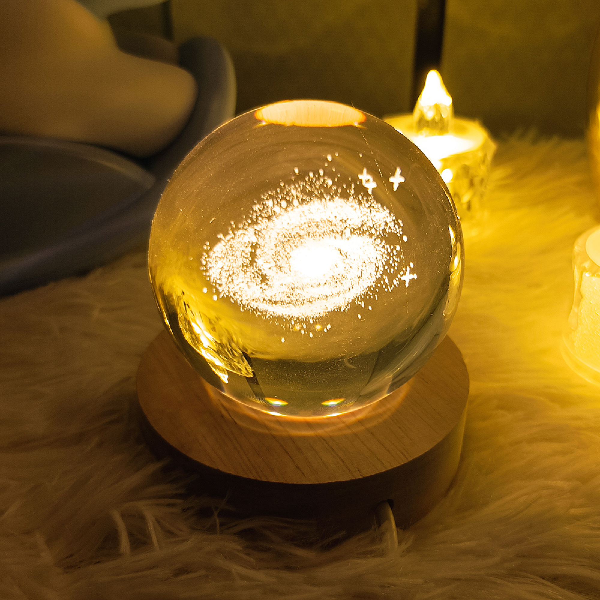 Eine leuchtende Kristallkugel auf einem Holzsockel zeigt eine 3D-Galaxie auf einer weichen, pelzigen Oberfläche.