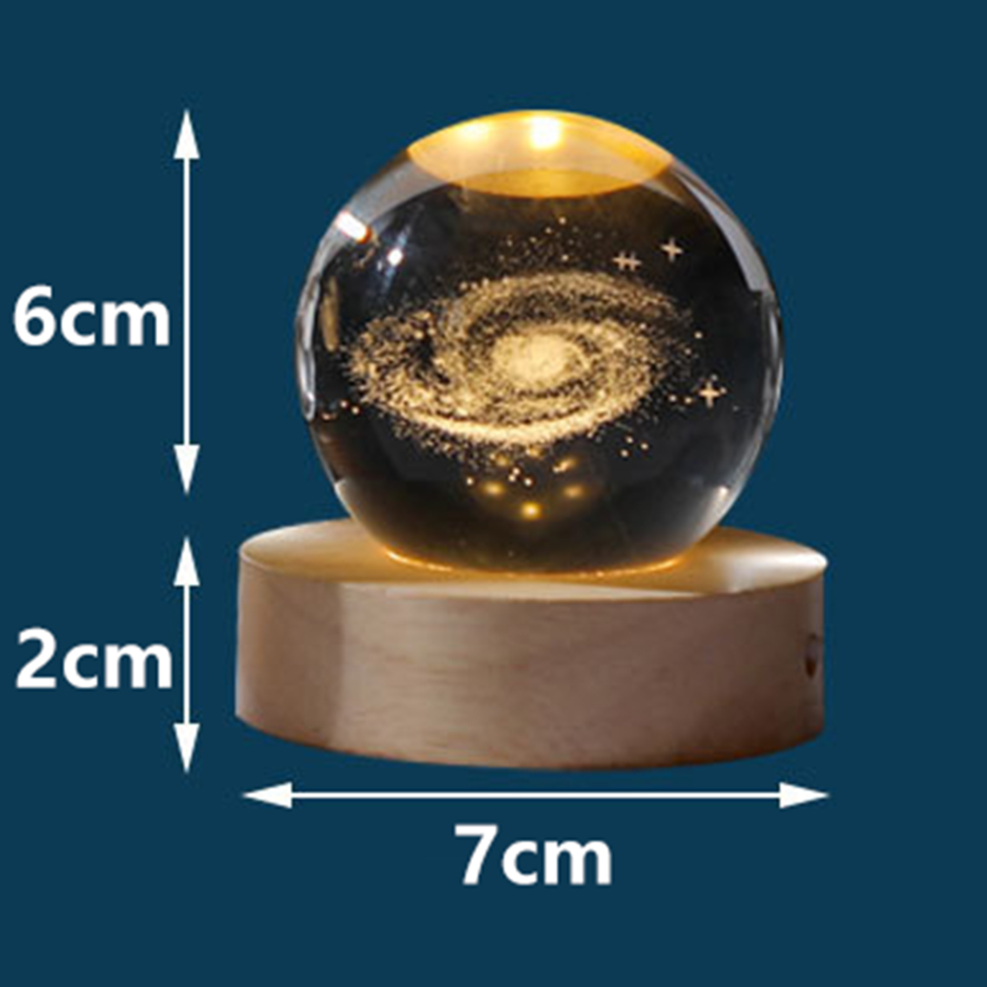 Beleuchtete Kristallkugel mit Galaxie-Motiv auf Holzsockel, Maße 6 cm hoch und 7 cm breit.
