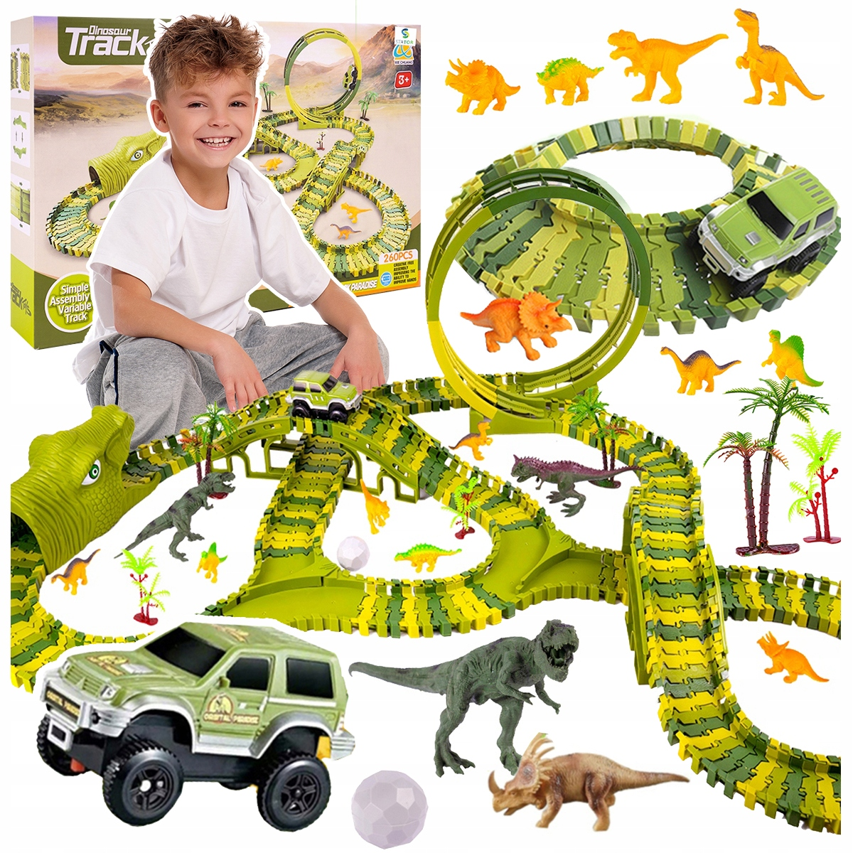 Chłopiec uśmiecha się obok toru wyścigowego z dinozaurami, autkami i palmami.