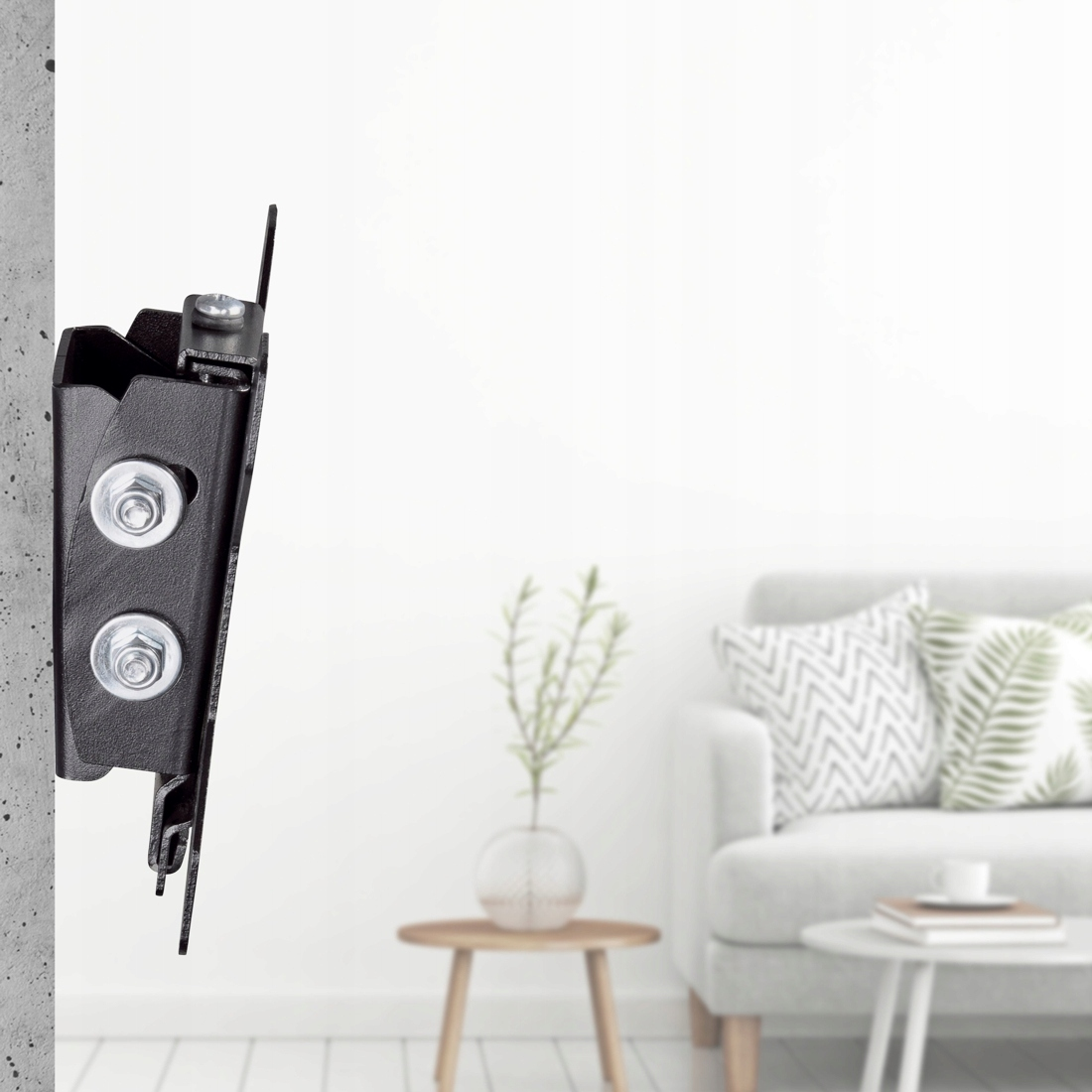 Un soporte de pared de metal negro está unido a una pared texturizada, con una sala borrosa de fondo.