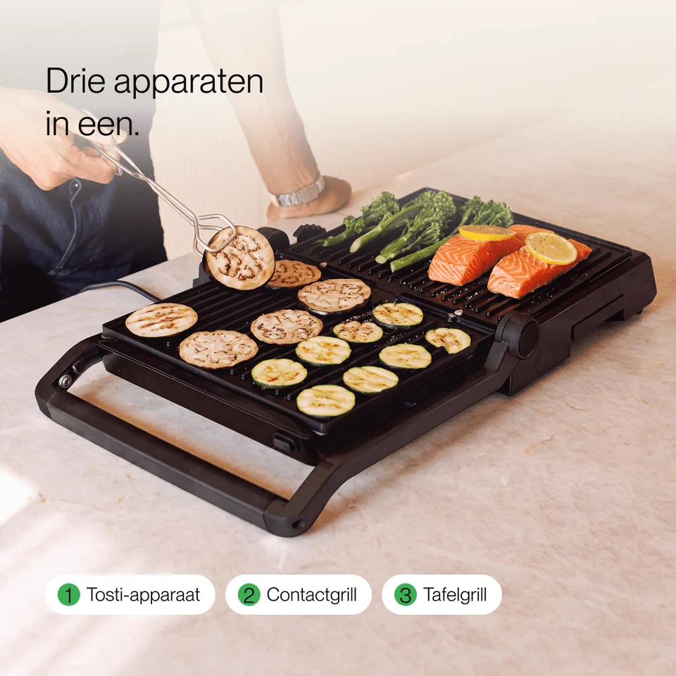 Personne faisant griller des légumes et du saumon sur un gril de table électrique.