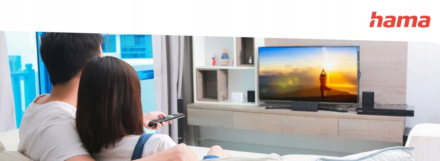 Para siedzi na kanapie oglądając telewizję i trzymając pilota.