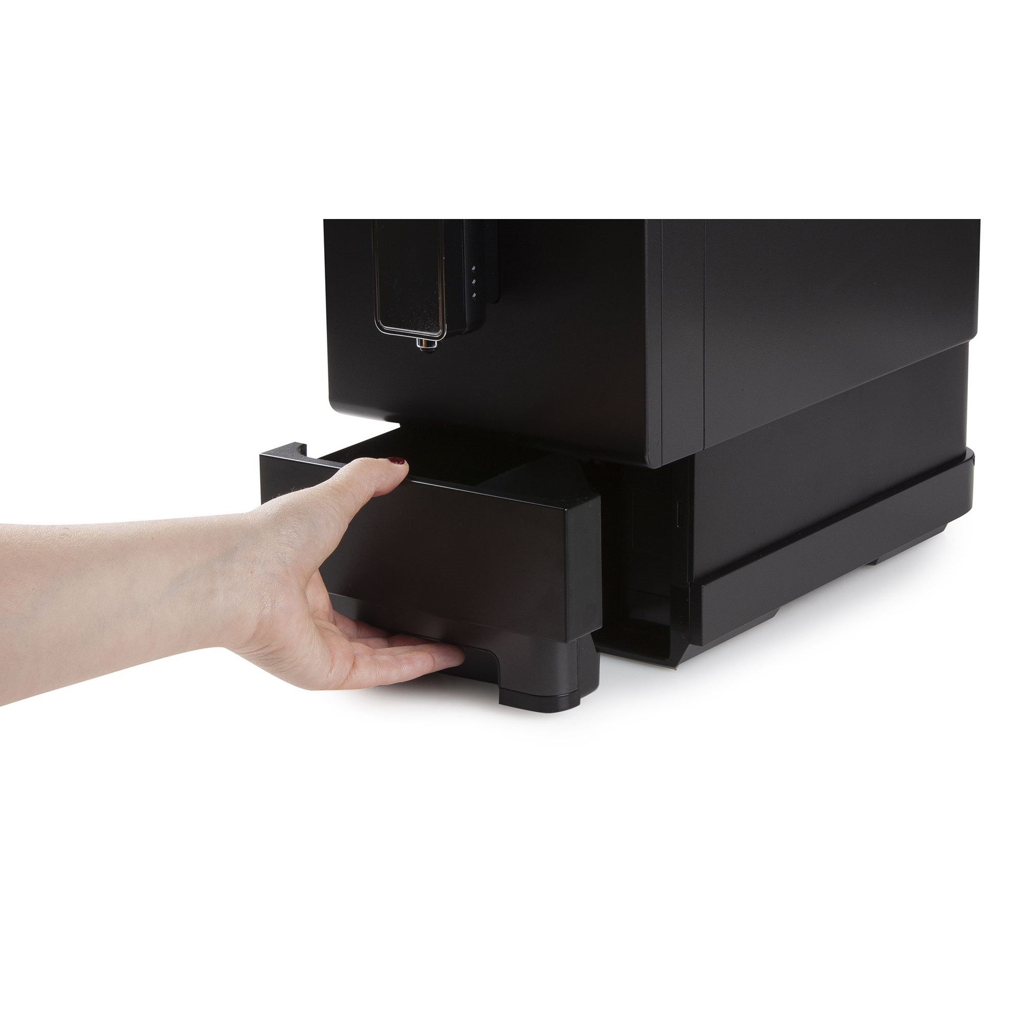 Eine Hand zieht eine schwarze Schublade unter einer schwarzen Kaffeemaschine auf weißem Hintergrund heraushafte.