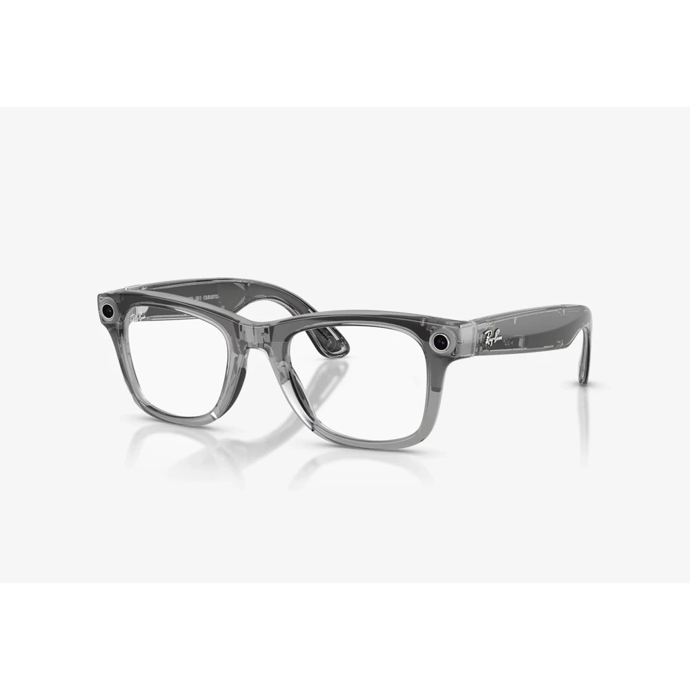 Kenarlarında dahili kameralar bulunan şeffaf gri Ray-Ban gözlük, sade beyaz arka plan üzerinde.