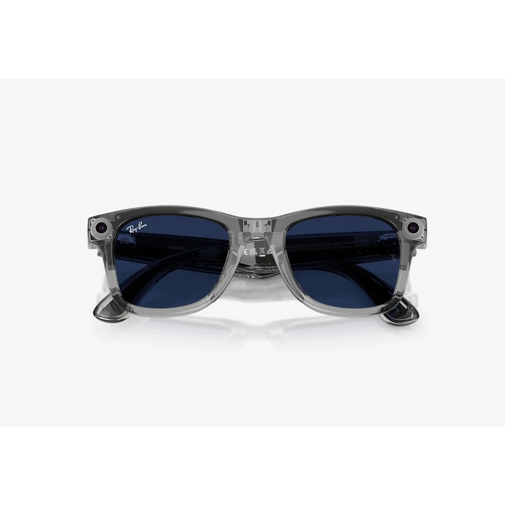 Beyaz arka planda mavi camlı ve entegre kameralı şeffaf Ray-Ban akıllı güneş gözlüğü.