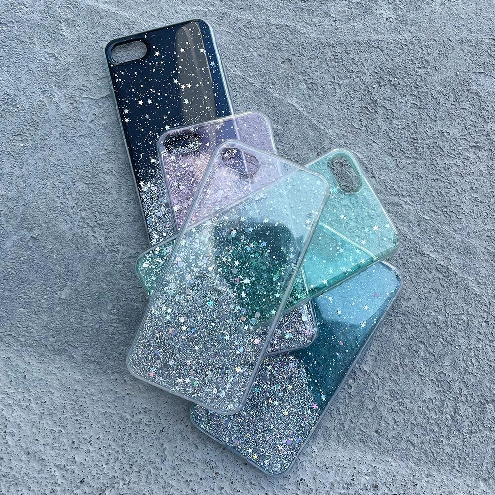 Diverse custodie per cellulari glitterate con motivi di stelle sono impilate su una superficie di cemento grigio.