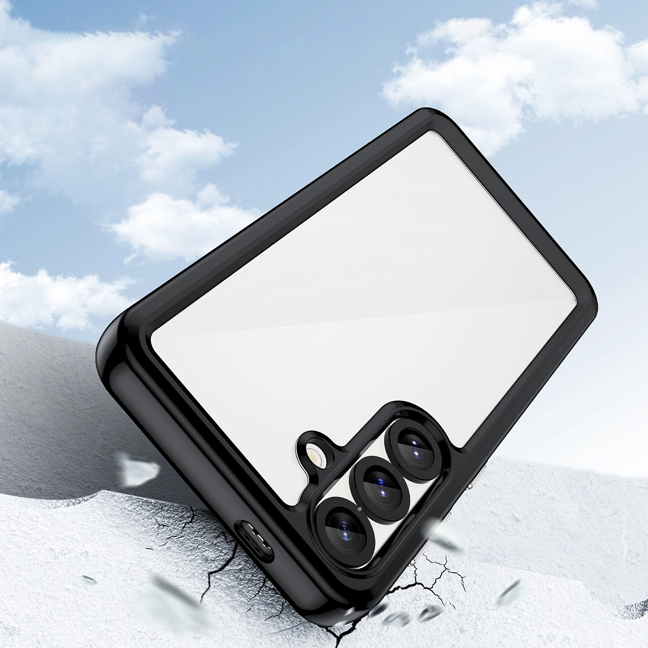 Una cover per smartphone nera giace su una superficie innevicata sotto un cielo azzurro.