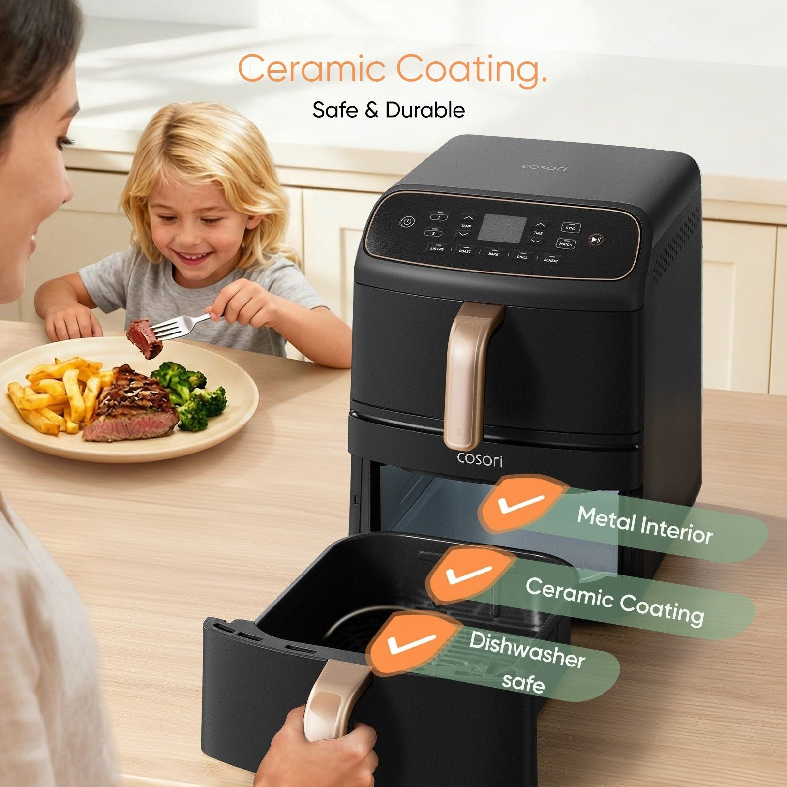 Een vrouw trekt de la van een zwarte airfryer open terwijl een kind op de achtergrond eet.