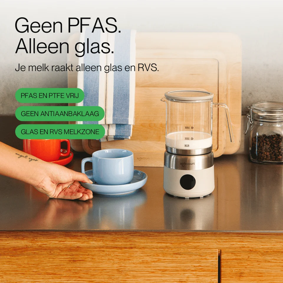 Glazen melkopschuimer met kopje op aanrecht, met tekst over PFAS-vrij in de achtergrond.
