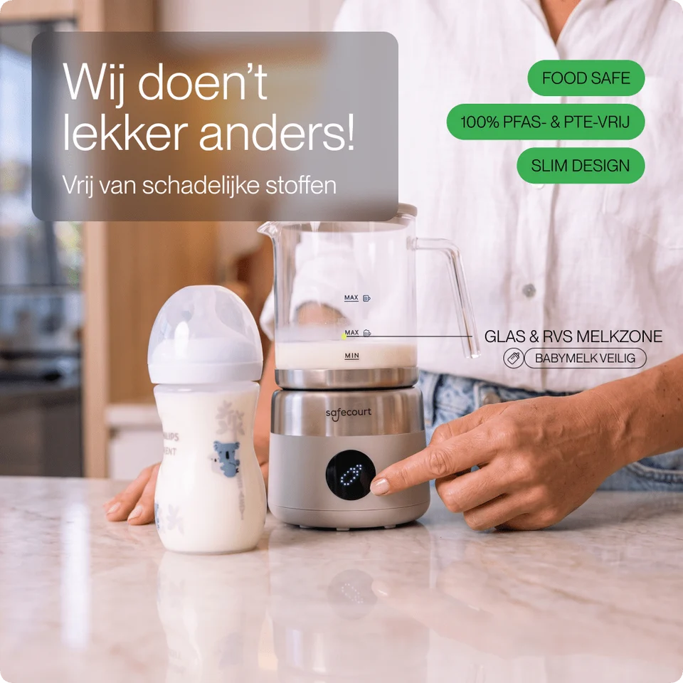 Iemand wijst naar een Safecourt melkopschuimer naast een babyfles op een marmeren aanrecht.