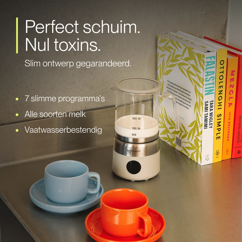 Glazen melkopschuimer op metalen aanrecht met blauwe en oranje kopjes en kookboeken.