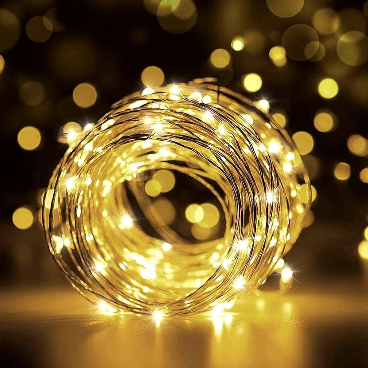 Eine spiralförmig aufgewickelte Lichterkette strahlt warmes, goldenes Licht in einer dunklen Umgebung aus.