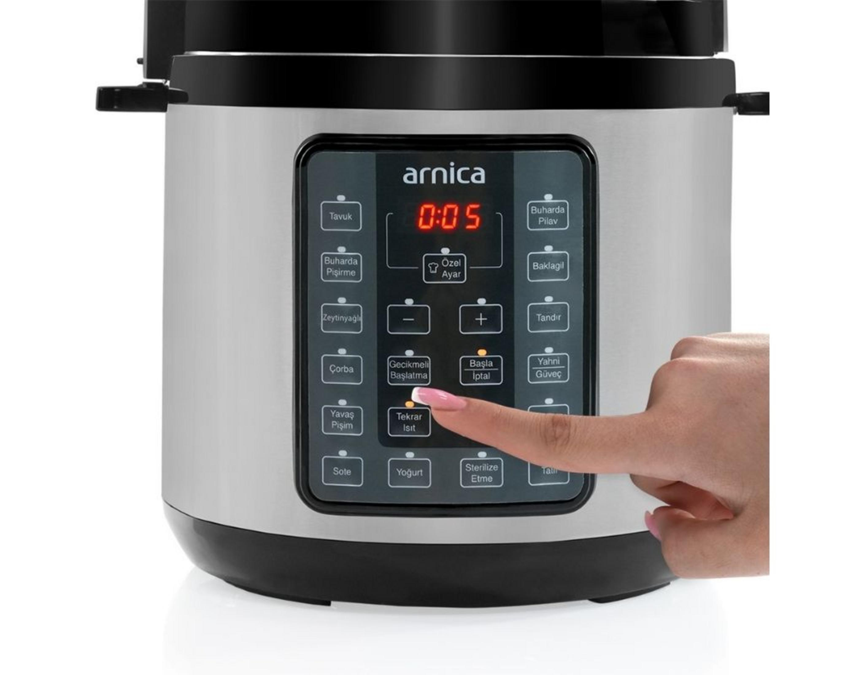 Dijital ekranlı gümüş renkli Arnica çok amaçlı pişiricinin düğmesine basan bir el.
