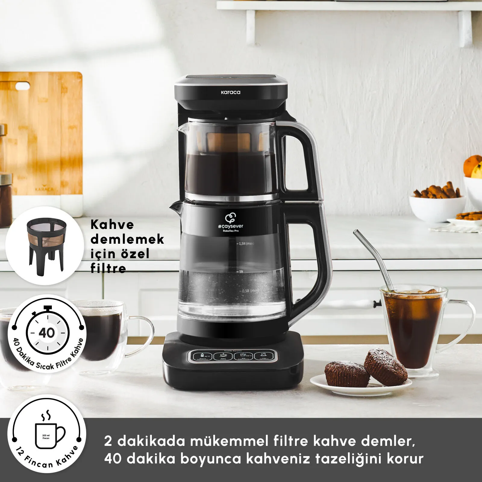 Mutfak tezgahında kahve fincanları ve kekler bulunan siyah Karaca RoboTea Pro çay makinesi.