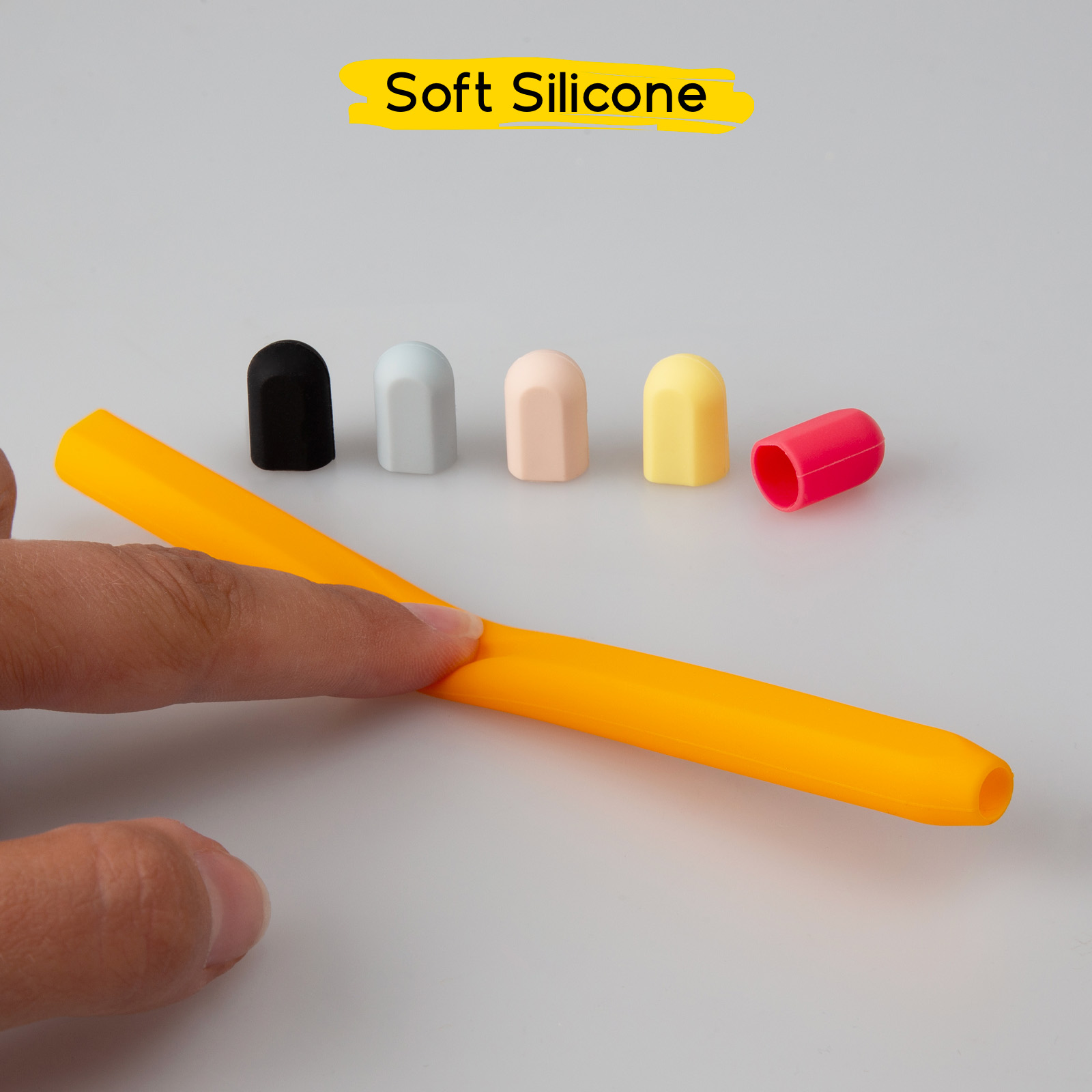 Un dito preme una penna in silicone arancione, con cinque tappi colorati allineati dietro su sfondo bianco.