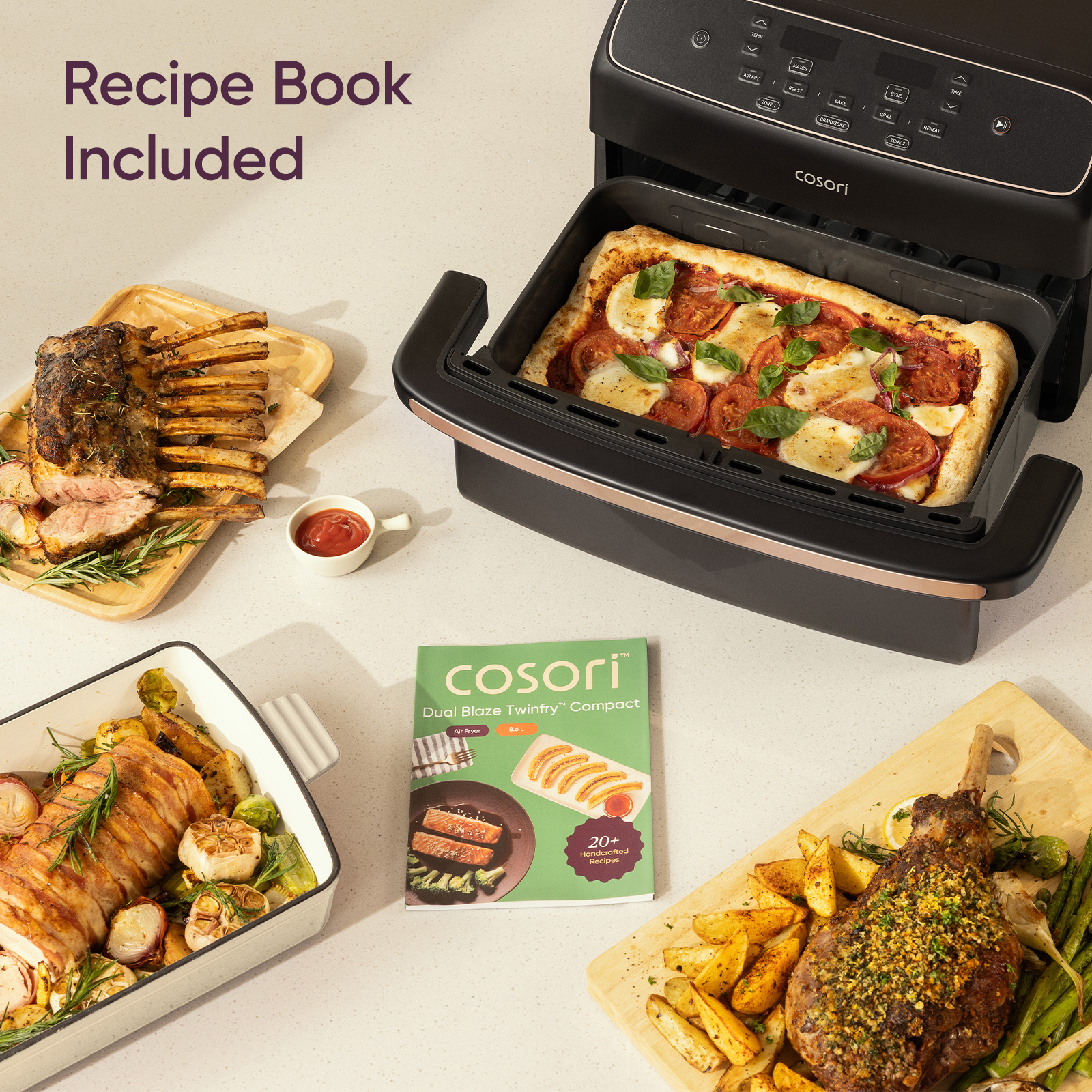 An air fryer, recipe book, and various cooked dishes like pizza, meat, and vegetables arranged on a kitchen counter.