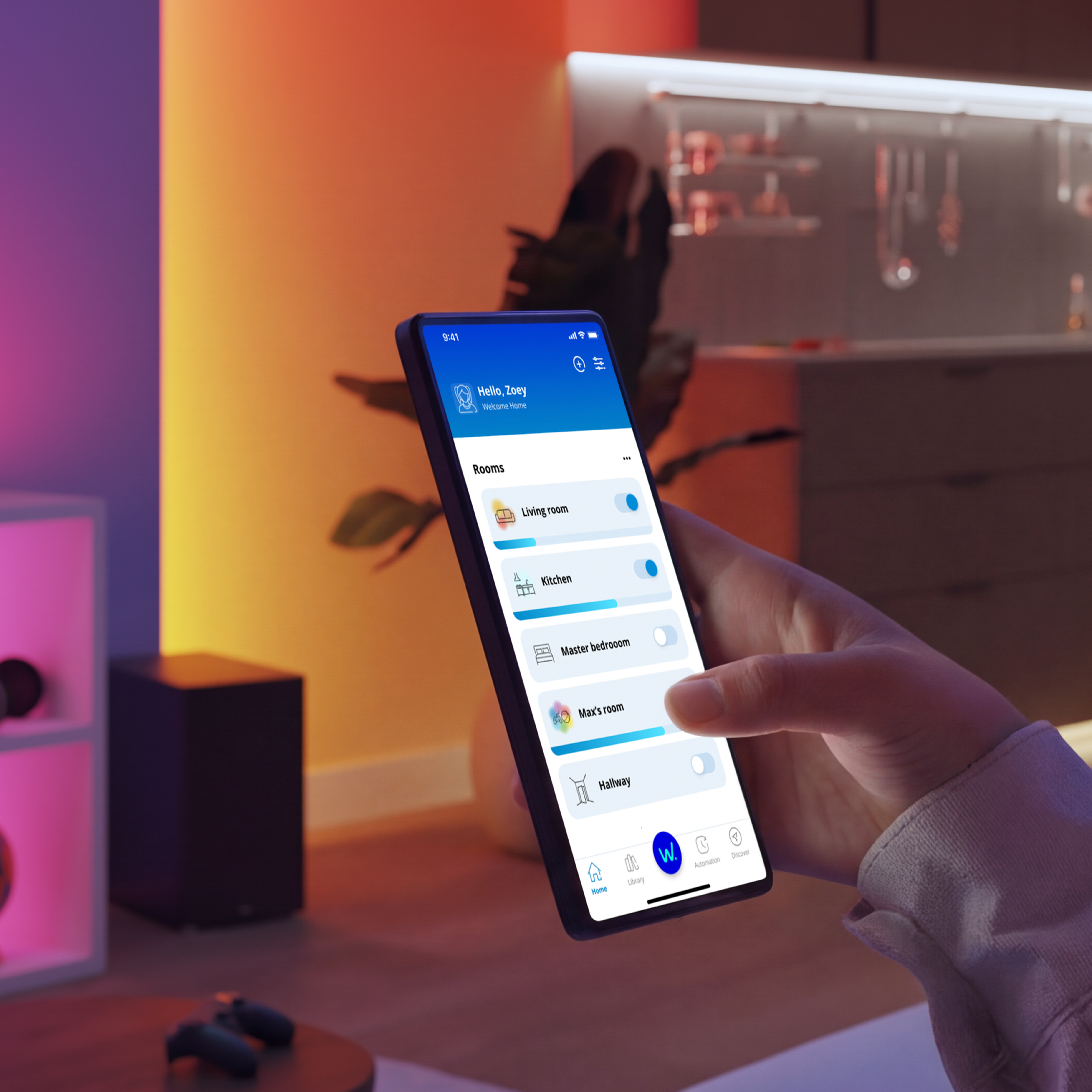 Dłoń trzyma smartfon z aplikacją do inteligentnego domu w nowoczesnym, ciepło oświetlonym pomieszczeniu z rośliną w tle.