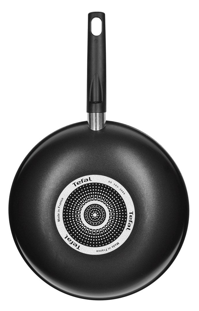 Parte inferior de una sartén negra Tefal con base de inducción circular y mango largo negro.