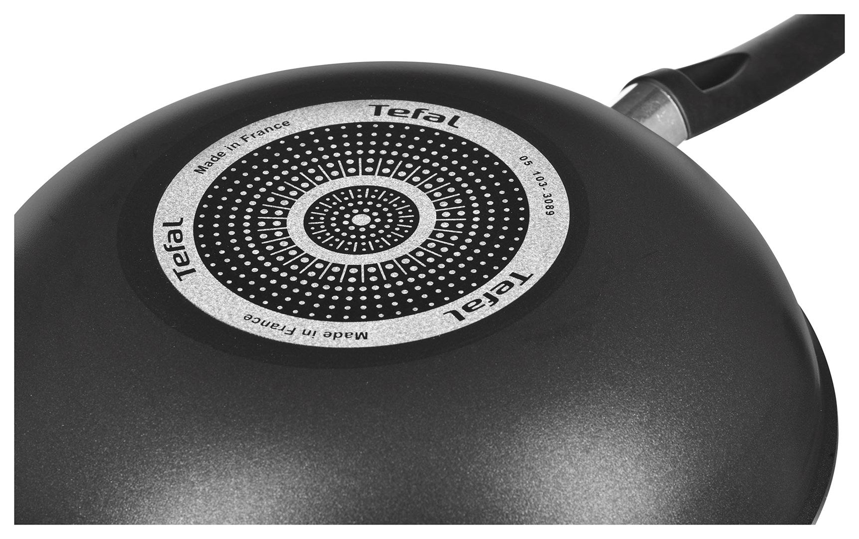 Vista inferior de una sartén negra Tefal con base de inducción estampada y mango.