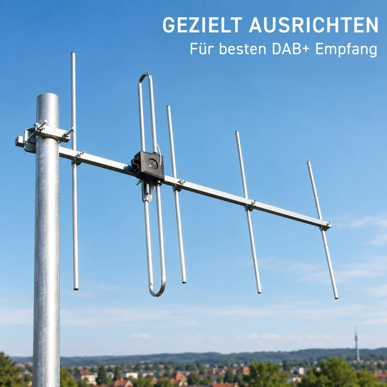 Eine metallische DAB+ Richtantenne an einem Mast vor klarem blauen Himmel und einer Stadt im Hintergrund.