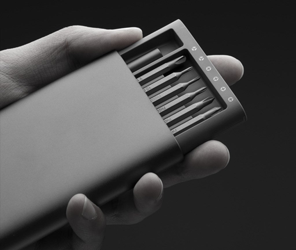 Una mano sostiene un estuche gris y elegante con varias puntas de destornillador.